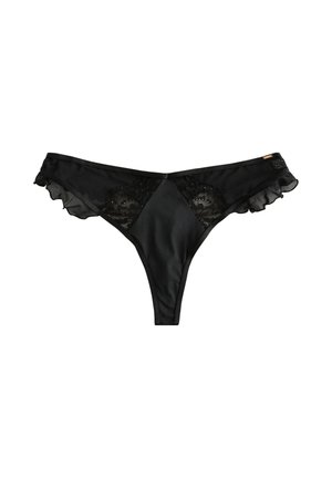 Kvinde i sort lingeri, gennemsigtige strømpebukser og satinjakke justerer jakken i marmorbad med toilettaske og cocktailglas.