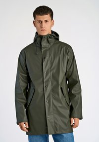 Impermeable verde con capucha, botones a presión, bolsillos laterales y una textura suave y brillante. Cuenta con un cordón ajustable en el cuello.