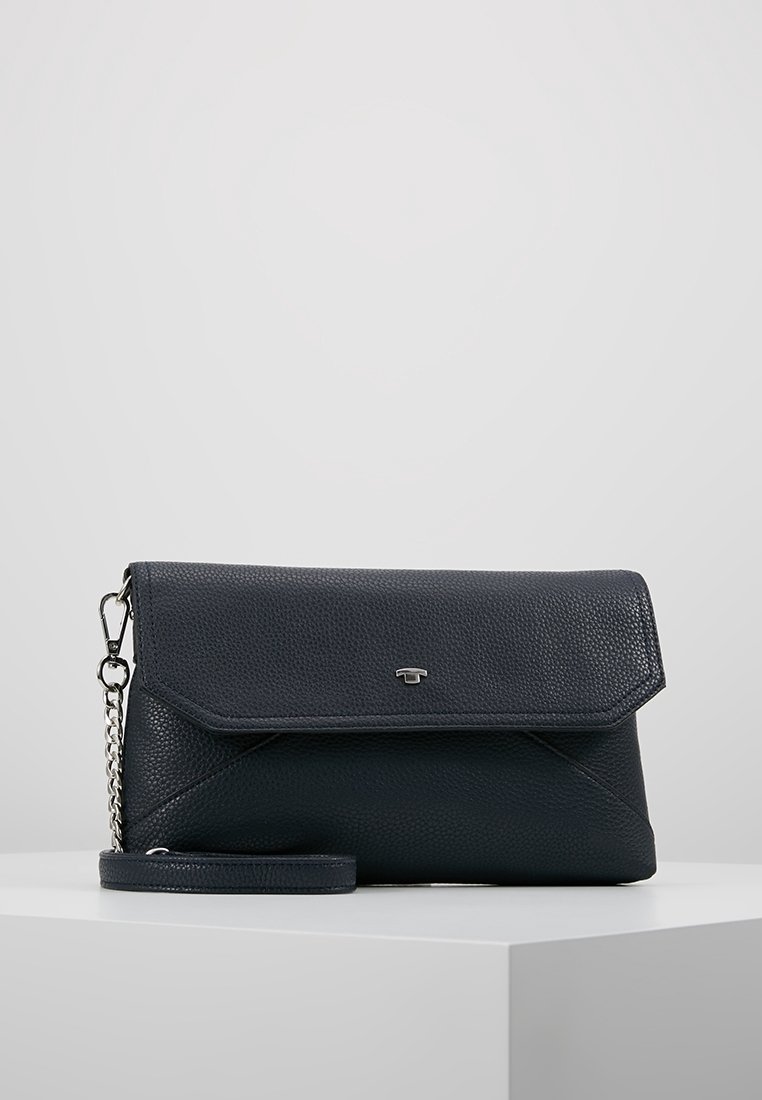 Mała czarna skórzana kopertówka o teksturze z klapą, srebrnym łańcuszkiem oraz minimalistycznym logo z przodu, wyeksponowana na białej powierzchni.