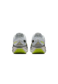 Scarpe sportive grigio chiaro con tomaia testurizzata, accenti verdi e suola in gomma caratterizzata da un motivo a ragno triangolare.