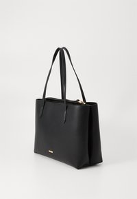 Schwarze Leder-Handtasche mit zwei langen Tragegriffen, einem Reißverschluss und einem minimalistischen Design mit einem kleinen goldenen Akzent auf der Vorderseite.