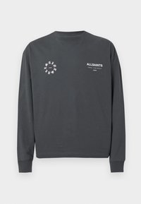 Σκούρο γκρι μπλουζάκι με μακριά μανίκια και λευκή επιγραφή «ALLSAINTS» καθώς και κυκλικό λογότυπο εκτυπωμένο στο στήθος, σε απλή ανοιχτόχρωμη φόντο.