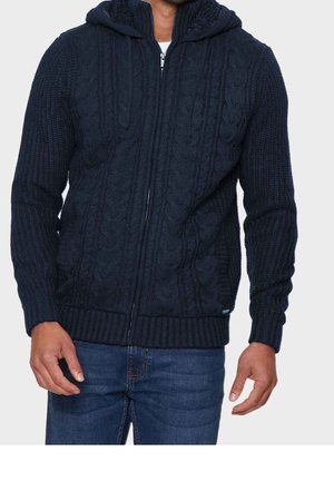 Granatowy, pleciony hoodie z zamkiem błyskawicznym, ozdobiony teksturowanym wzorem w warkocze, z prążkowanymi mankietami i dołem oraz podszytym kapturem. Posiada srebrny detal zamka.