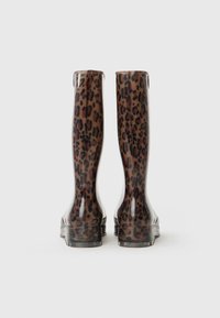 Bottes de pluie en caoutchouc à imprimé léopard avec une finition brillante, présentant un haut tige et des semelles texturées pour une meilleure adhérence.