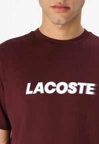 Lacoste Marškinėliai su spaudiniu - expresso