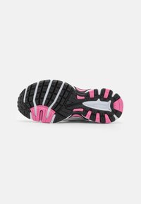Suola di scarpe da corsa con una base in gomma nera, accenti rosa e grigi, motivo testurizzato e tacchetti di trazione prominenti per aderenza.