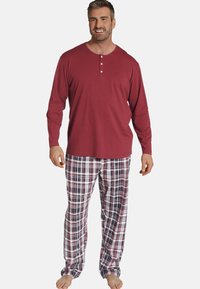 Red long-sleeve henley top with three buttons, paired with plaid trousers featuring white, maroon, and navy colors. Soft fabric, relaxed fit.