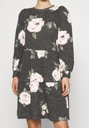 Mørkegrå kjole med lange ærmer med stort sart rosa og grønt blomsterprint, tætsiddende talje og rund halsudskæring.