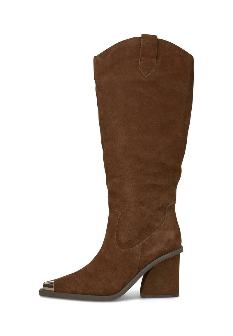 Bota de ante marrón hasta la rodilla con punta afilada, acento metálico en la punta y tacón grueso. Textura suave con diseño de caña curvada.