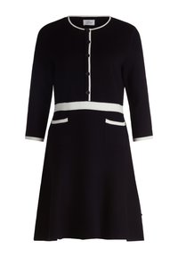 Robe en tricot noire à manches trois-quarts, avec un liseré blanc le long de l'encolure et de la taille, dotée de six boutons et de deux poches avant.