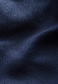 Marineblauer, strukturierter Stoff mit glatter Oberfläche, der feine Unterschiede im Gewebe und einen weichen Fall zeigt, wodurch sanfte Wellen entstehen.