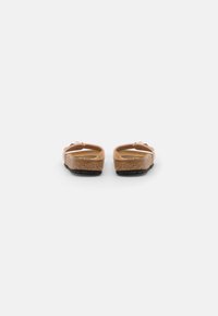 Sandales en liège brun avec un design minimaliste, dotées d'une couche supérieure lisse et beige clair et de semelles en caoutchouc noir pour une traction optimale.