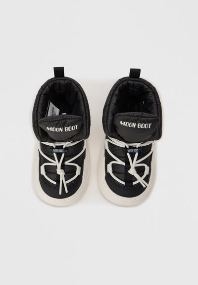 Czarne buty Moon Boots z wyściełanym cholewką, białymi sznurówkami i kontrastującymi białymi podeszwami. Logo na języku i z tylu, z teksturowanym wnętrzem.