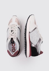 Baskets avec une tige en feutre gris, des accents beiges, des détails en métal argenté et une semelle en caoutchouc noir ; lacets et logo visibles à l'intérieur.