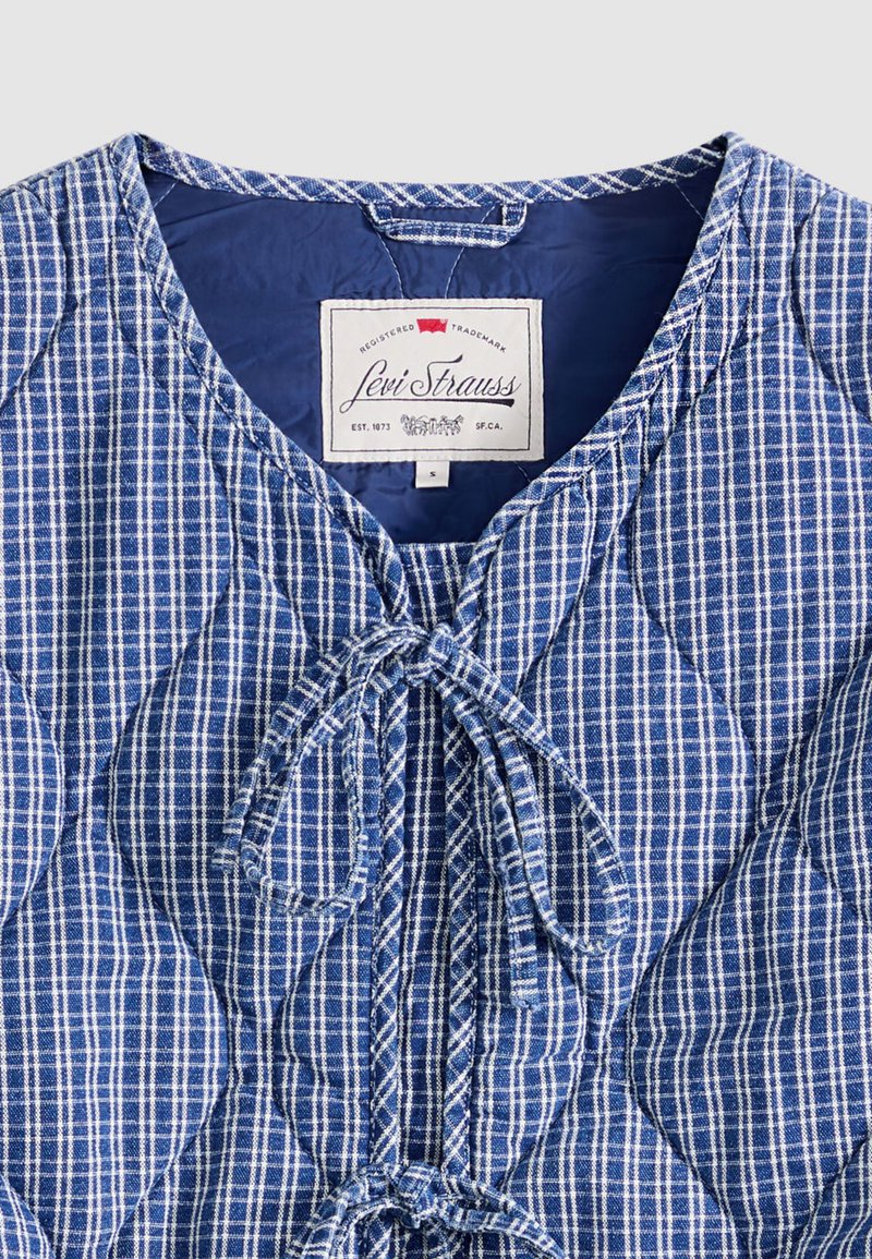 Tissu matelassé à carreaux bleus et blancs avec fermeture à nouer à l'avant et étiquette Levi Strauss à l'intérieur du col, taille petite.