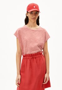 Red cap with a white logo, red skirt with elastic waistband, and a red and white striped short-sleeve top. Soft fabric, casual design.