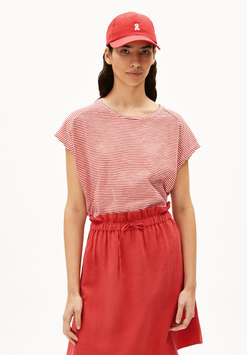 Red cap with a white logo, red skirt with elastic waistband, and a red and white striped short-sleeve top. Soft fabric, casual design.