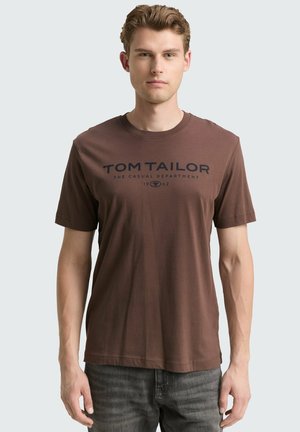Bruine katoenen t-shirt met korte mouwen en een ronde hals. Voorzien van een donkerblauwe bedrukte logo-tekst over de borst.