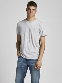Camiseta gris de manga corta hecha de una mezcla de algodón con un cuello redondo; presenta un pequeño logo en el lado izquierdo del pecho y un corte relajado.