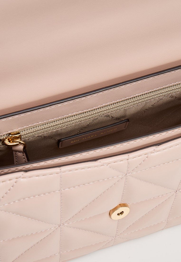 Sac à main en cuir rose clair matelassé avec un fermoir à pression doré et une poche zippée à l'intérieur. Motif géométrique texturé à l'extérieur.