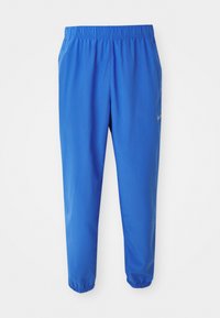 Blue athletic pants with elastic waistband, straight leg design, and tapered cuffs. Features Nike logo in gold on the left side.