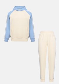 Hoodie crème avec manches raglan bleu clair et pantalon de jogging crème assorti avec bandes latérales bleu clair, présenté sur un fond uni.