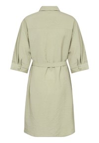 Vestito camicia verde chiaro con colletto, maniche a tre quarti, polsini con bottoni e vita con cintura. Tessuto testurizzato con un delicato motivo geometrico.