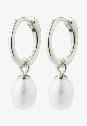 Srebrne kolczyki w kształcie kół z białą perłą na końcu. Koła mają polerowane wykończenie i gładką, okrągłą perłę przymocowaną u podstawy.