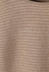 Beżowa, prążkowana tkanina dzianinowa z poziomymi, teksturowanymi paskami oraz miękkim, lekko elastycznym wyglądem.