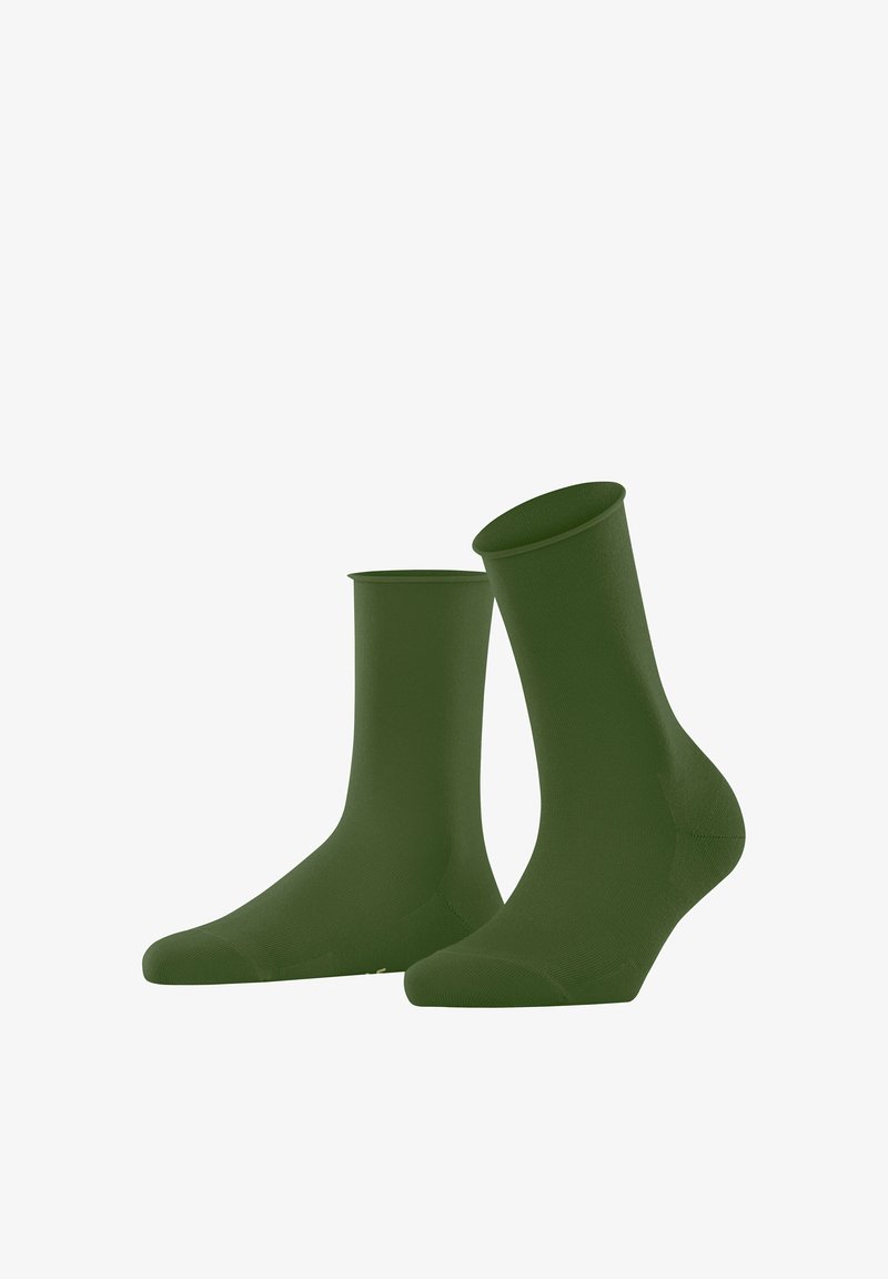 Een paar effen, donker groene sokken van tot halverwege de kuit, rechtopstaand tegen een witte achtergrond.