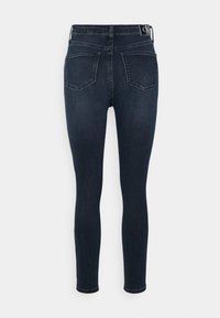 Jeans ajustados de mezclilla azul oscuro con cintura media, diseño de cinco bolsillos y detalles de costura sutiles en los bolsillos traseros.