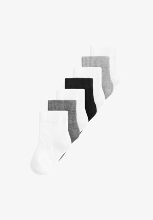 Sept chaussettes courtes aux couleurs alternées : blanc, gris, noir, gris et blanc, disposées en diagonale.