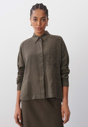 Olive green button-up shirt made of lightweight fabric. Features a collar, long sleeves, and a chest pocket. Simple design with subtle texture.