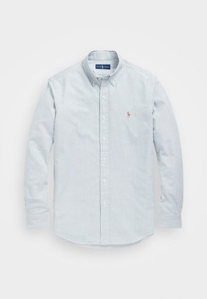 Chemise à manches longues boutonnée, avec fines rayures verticales grises et petit logo brodé sur la poitrine gauche, col boutonné.