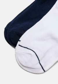 Chaussettes en mélange de coton avec un design éclaté en bleu marine et blanc, texture côtelée et détail de couture contrasté le long des bords.