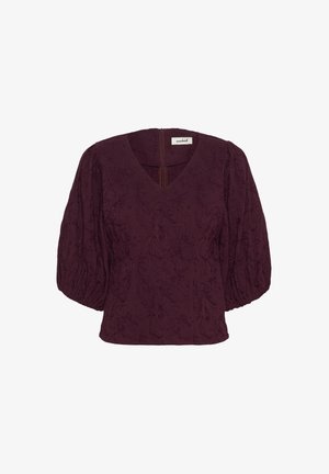 Burgundy blouse with puffed sleeves, V-neck, textured floral pattern, and back zipper closure. Designed for a relaxed fit.