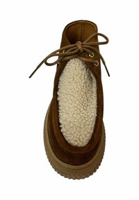 Zapato de ante marrón con cordones, forrado de una suave crema y con una suela texturizada y gruesa. Presenta ojales dorados y un diseño de punta redonda.