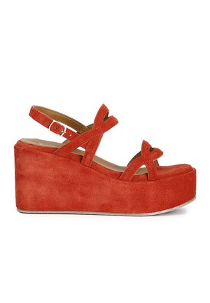 Sandale compensée plateforme en daim rouge avec brides croisées et boucle de cheville réglable, vue de profil sur fond blanc.