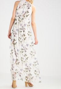 Robe longue en tissu léger et fluide, à motif floral avec des accents verts et violets, taille froncée et décolleté licou.