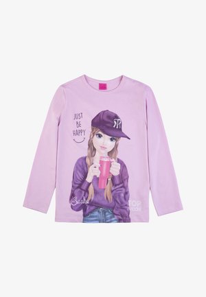 Light purple long-sleeve shirt featuring a graphic of a girl in a dark purple cap, holding a pink drink and surrounded by text, "JUST BE HAPPY."
