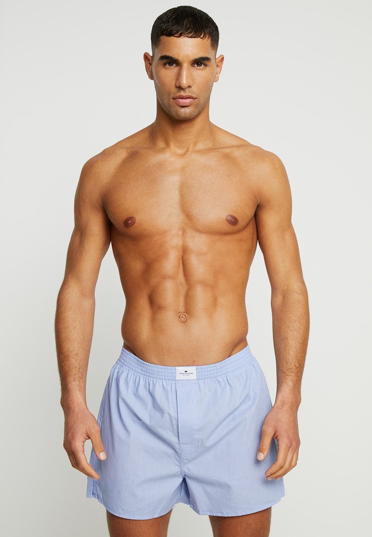 Lichtblauwe katoenen shorts met een elastische tailleband en een opening aan de voorkant, met een gestructureerde stof en een label op de tailleband.
