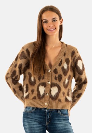 Gilet imprimé léopard dans des tons beiges et marron, avec un col en V, des manches longues et une fermeture à cinq boutons. Tissu doux et texturé.