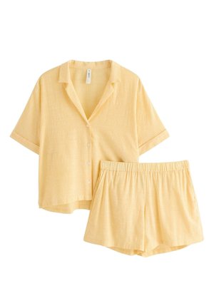 Camicia gialla chiara a maniche corte con bottoni e pantaloncini con vita elasticizzata abbinati, entrambi caratterizzati da sottili righe verticali.