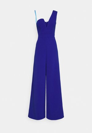 Koningsblauwe jumpsuit met wijde pijpen, één brede schouderband en één dunne spaghettiband, met een diepe V-hals.