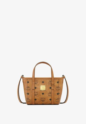 Tan leather handbag with structured shape. Features double top handles, removable shoulder strap, gold-tone hardware, and printed logo design.