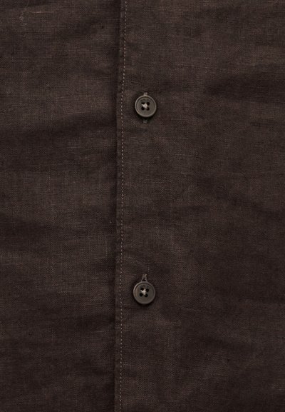Σκούρο καφέ ύφασμα με δύο μαύρα κουμπιά ραμμένα σε μια κάθετη ραφή, ορατή ραφή και ελαφρές μεταβολές στην υφή.