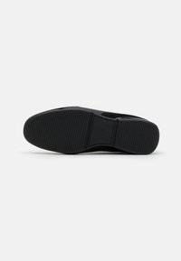 Semelle de chaussure noire avec des rainures horizontales et une surface texturée. Caoutchouc durable avec un design simple et épuré. Motif de bande de roulement antidérapant.