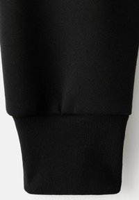 Čierny bavlnený sveter na rukávoch s rybkovou textúrou. Vyznačuje sa tesným, elastickým strihom a hladkým povrchom látky.