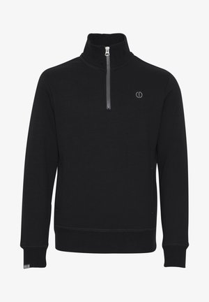 Fekete pulóver, puha anyagból készült, magas gallérral, cipzáros zárással és egy kis logóval a mellrészen. Bordás mandzsettákkal és szegéllyel rendelkezik.