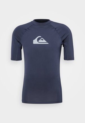 Námornícky krátky rukáv rash guard vyrobený z elastického materiálu. Obsahuje svetlošedé logo na hrudi a ploché švy pre pohodlie.